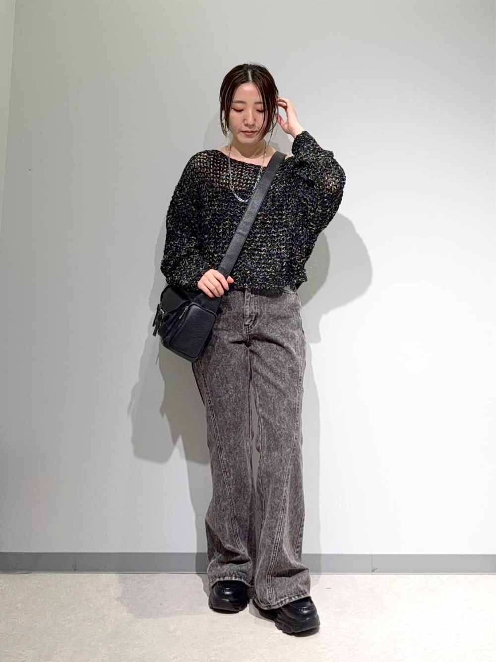 ブラック系のニット/セーター、ブラック系のデニムパンツ、ブラック系のショルダーバッグを着用したレディースの夏コーディネートの1枚目の写真