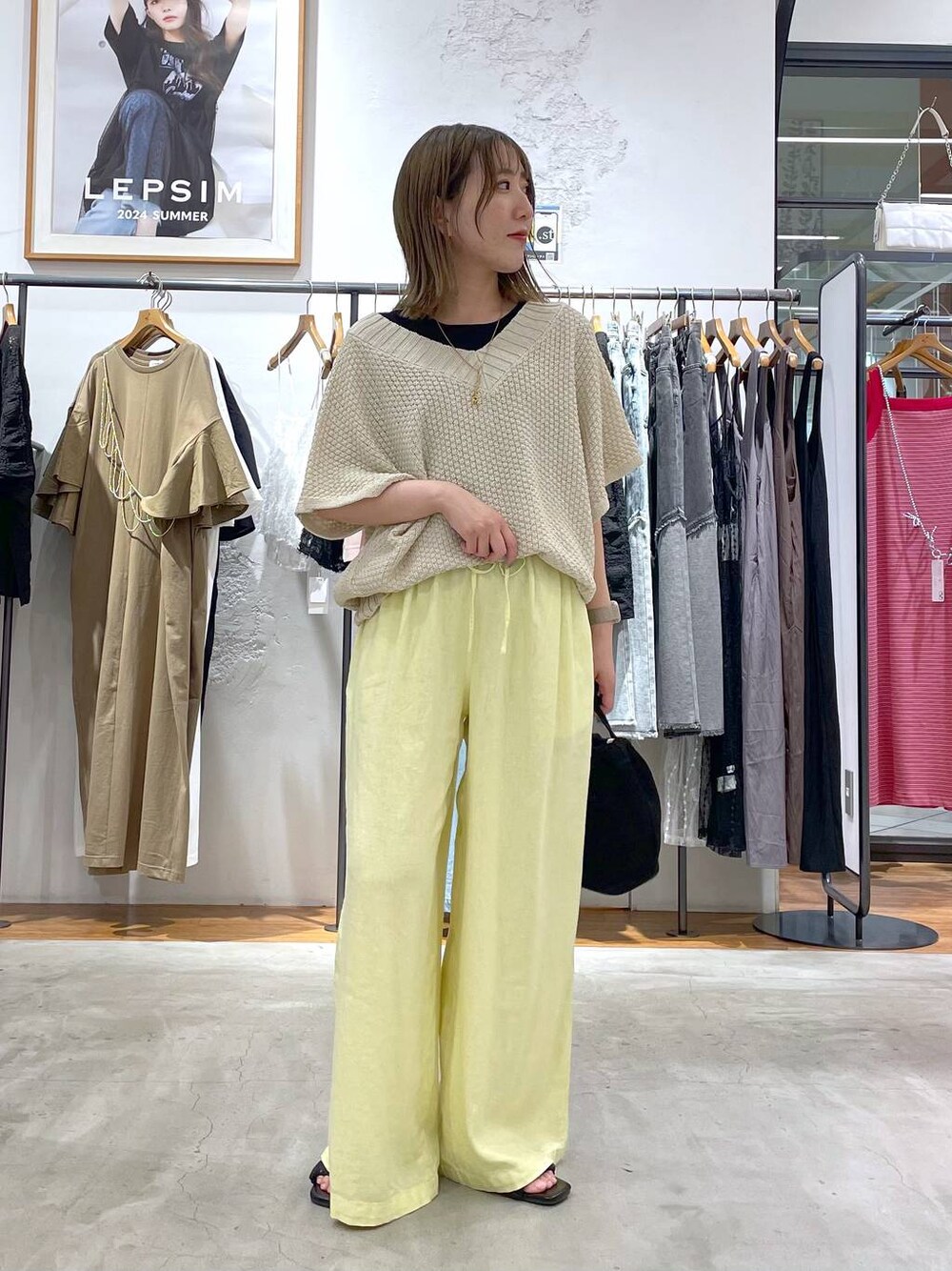 ブラック系のタンクトップ、イエロー系のその他パンツ、ブラック系のショルダーバッグを着用したレディースの夏コーディネートの1枚目の写真