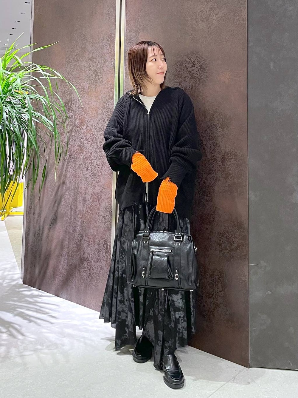 ブラック系のボストンバッグ、ホワイト系のニット/セーター、ブラック系のパーカーを着用したレディースの秋コーディネートの1枚目の写真