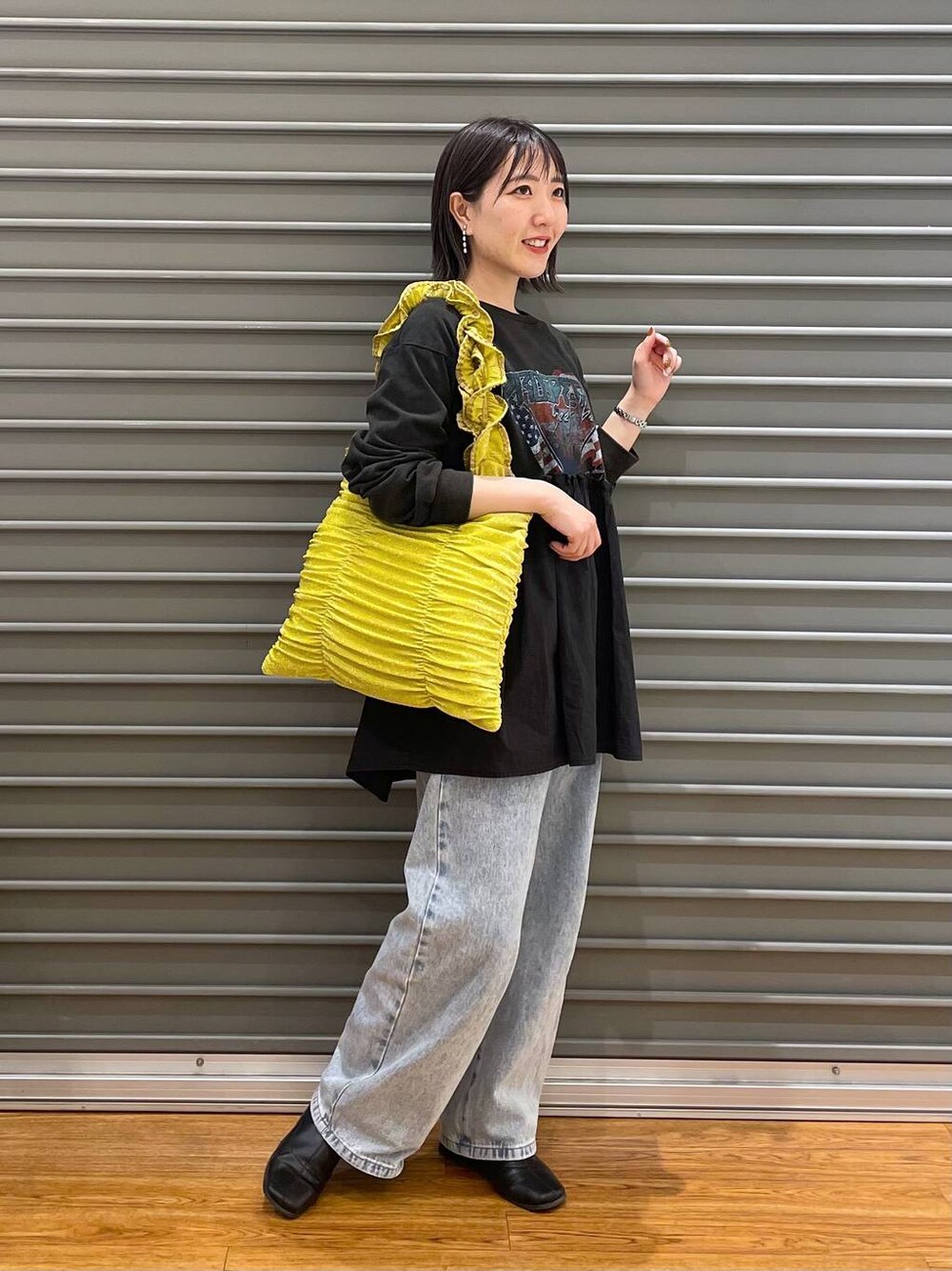 イエロー系のトートバッグ、ブルー系のデニムパンツ、グレー系のTシャツ/カットソーを着用したレディースの春コーディネートの1枚目の写真