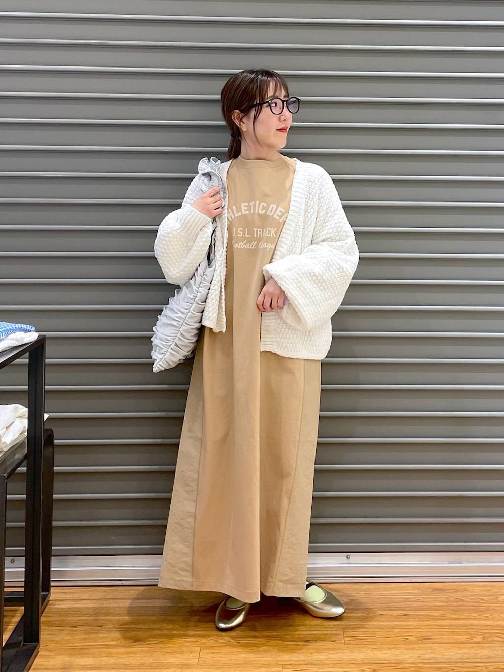 ゴールド系のバレエシューズ、ホワイト系のカーディガン/ボレロ、シルバー系のトートバッグを着用したレディースの春コーディネートの1枚目の写真