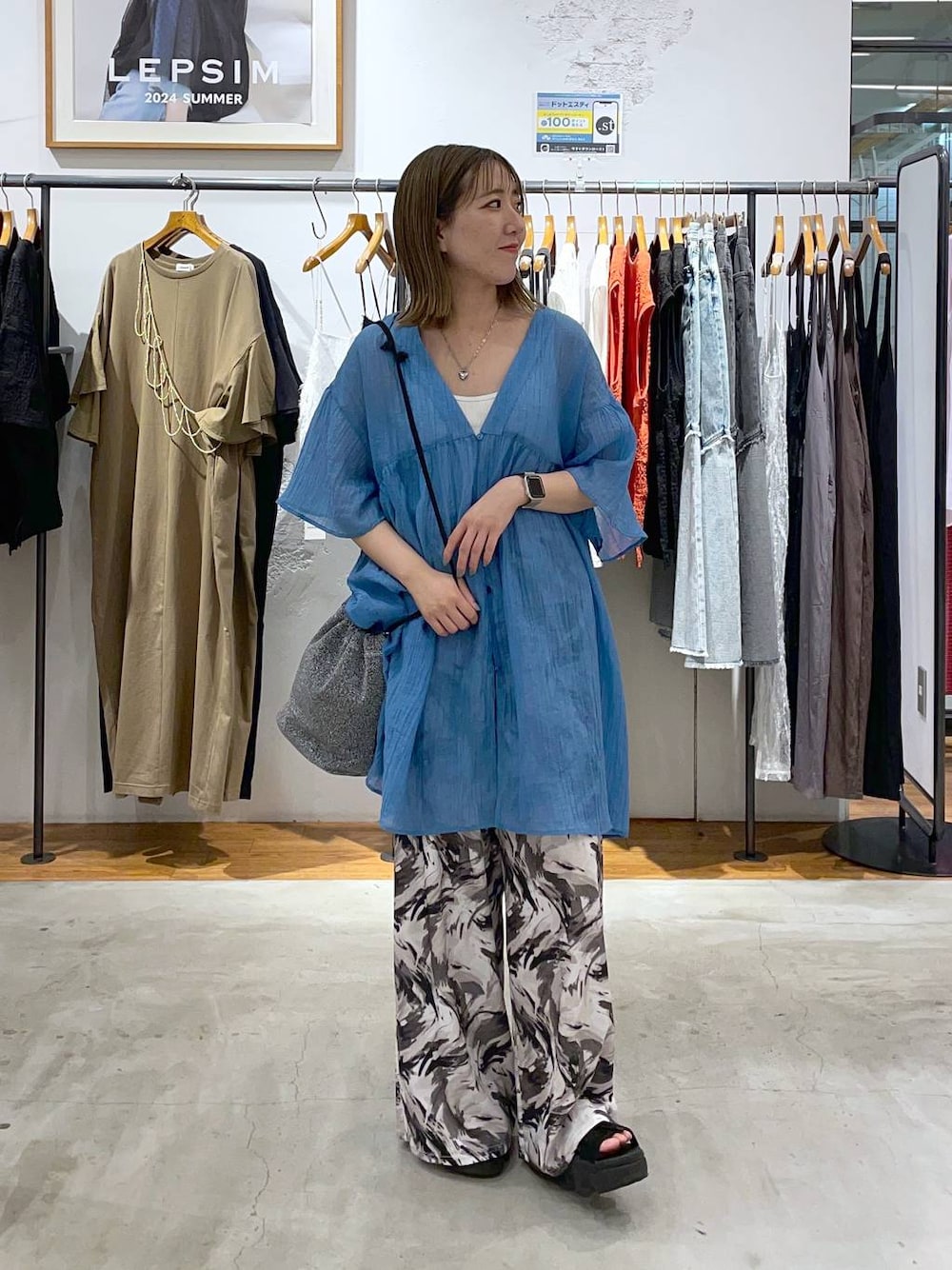 グレー系のショルダーバッグ、ブラック系のその他パンツ、ブルー系のチュニックを着用したレディースの夏コーディネートの1枚目の写真