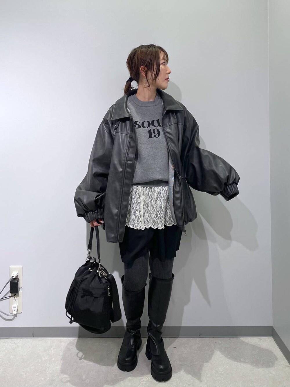 ブラック系のショルダーバッグ、ブラック系のブーツ、ブラック系のブルゾンを着用したレディースの冬コーディネートの1枚目の写真