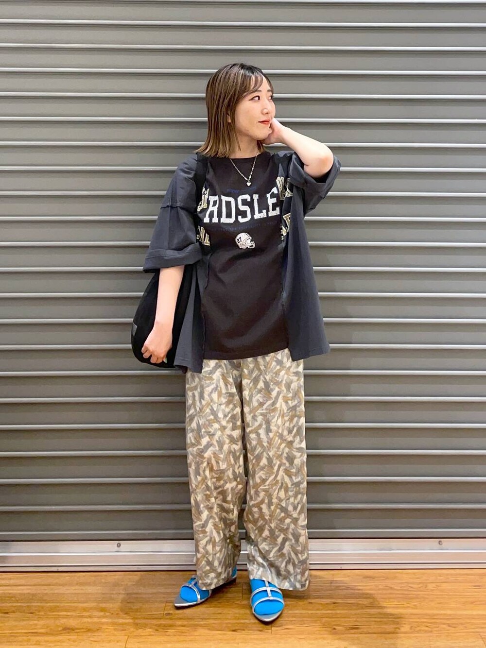 ブラック系のショルダーバッグ、ブラック系のTシャツ/カットソー、グレー系のその他パンツを着用したレディースの春コーディネートの1枚目の写真