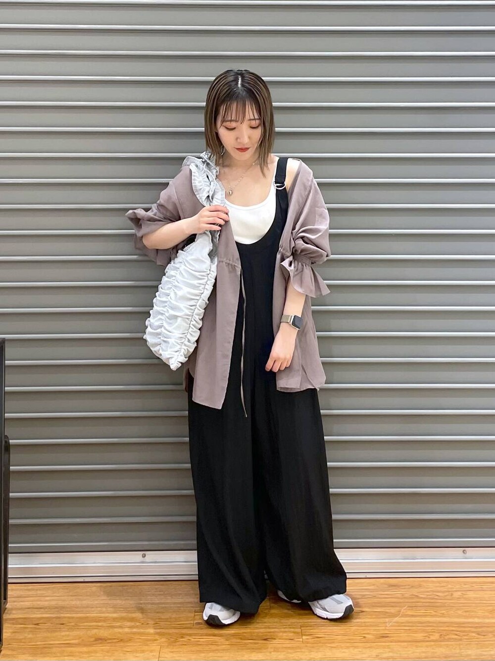 グレー系のスニーカー、シルバー系のトートバッグ、ブラウン系のシャツ/ブラウスを着用したレディースの春コーディネートの1枚目の写真