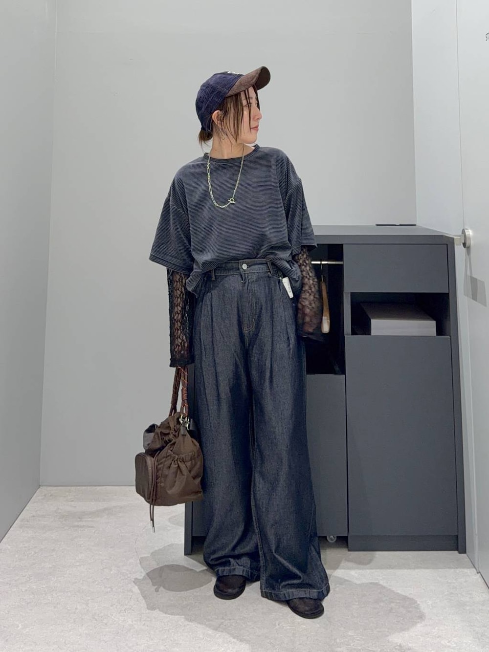 グリーン系のTシャツ/カットソー、ブラウン系のショルダーバッグ、ブルー系のデニムパンツを着用したレディースの夏コーディネートの1枚目の写真