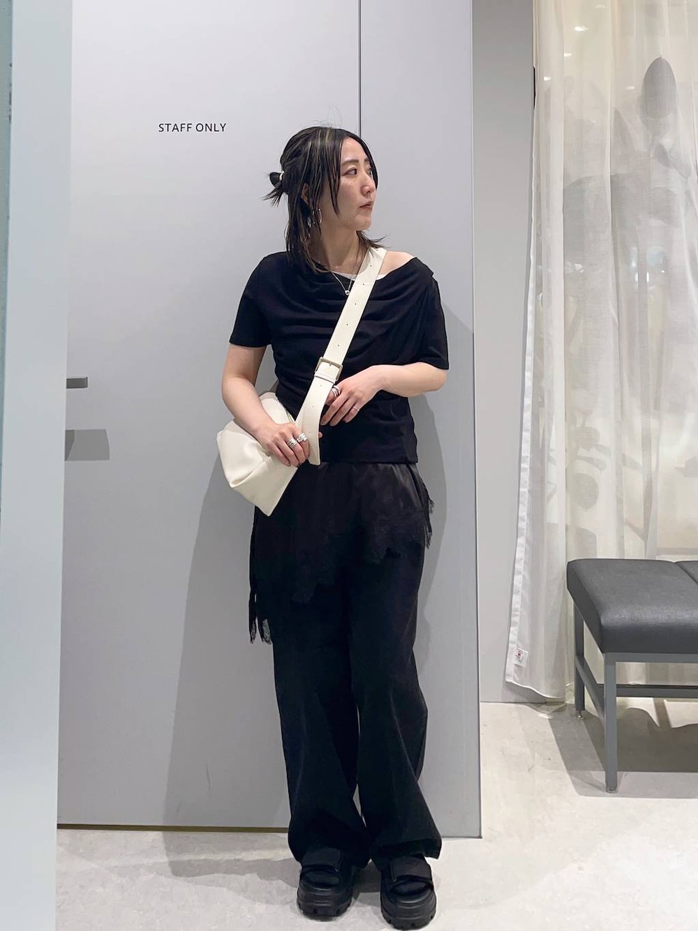 ブラック系のTシャツ/カットソー、ブラック系のサンダル、ホワイト系のショルダーバッグを着用したレディースの春コーディネートの1枚目の写真