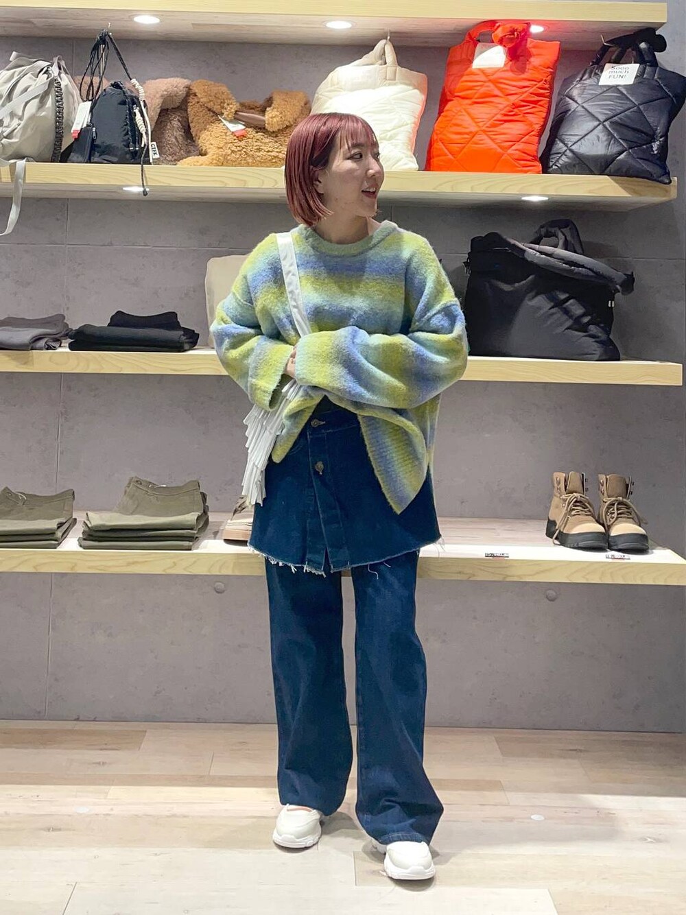 ホワイト系のスニーカー、シルバー系のトートバッグ、グリーン系のニット/セーターを着用したレディースの冬コーディネートの1枚目の写真