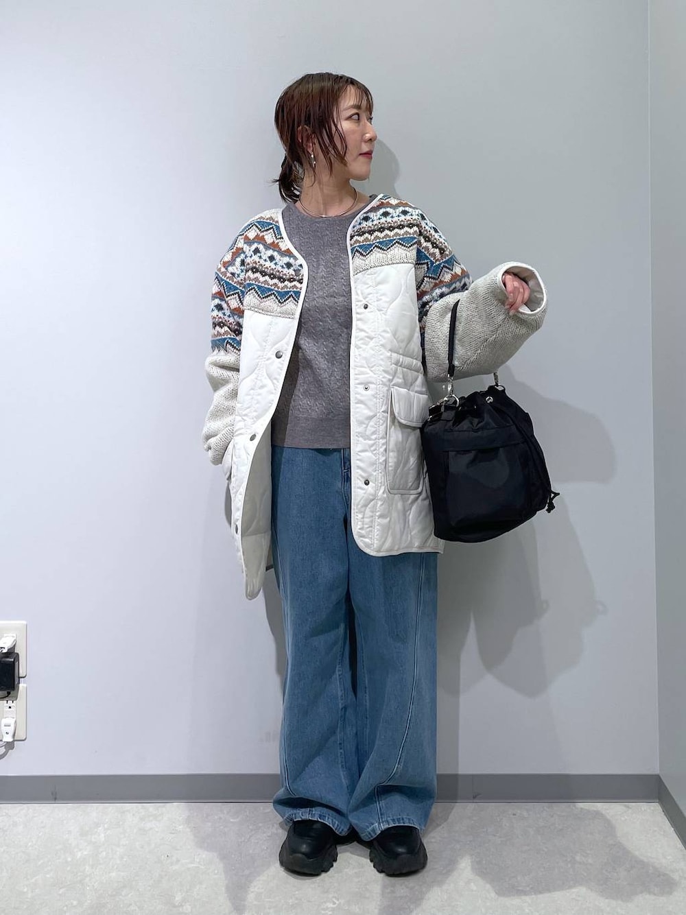 ブラック系のショルダーバッグ、グレー系のニット/セーター、ベージュ系のブルゾンを着用したレディースの冬コーディネートの1枚目の写真