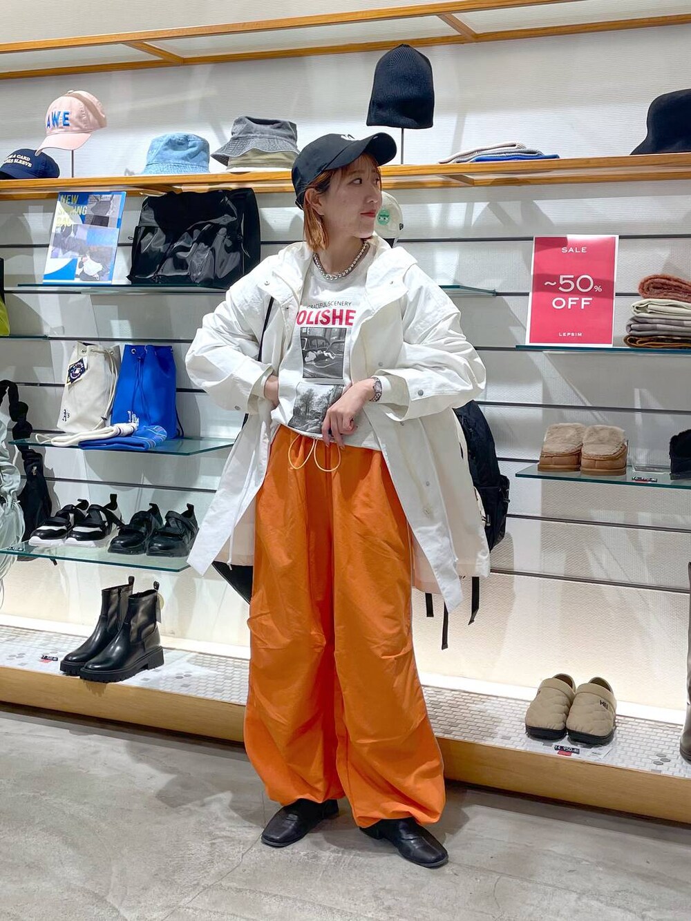 オレンジ系のその他パンツ、ホワイト系のその他アウター、グレー系のTシャツ/カットソーを着用したレディースの春コーディネートの1枚目の写真