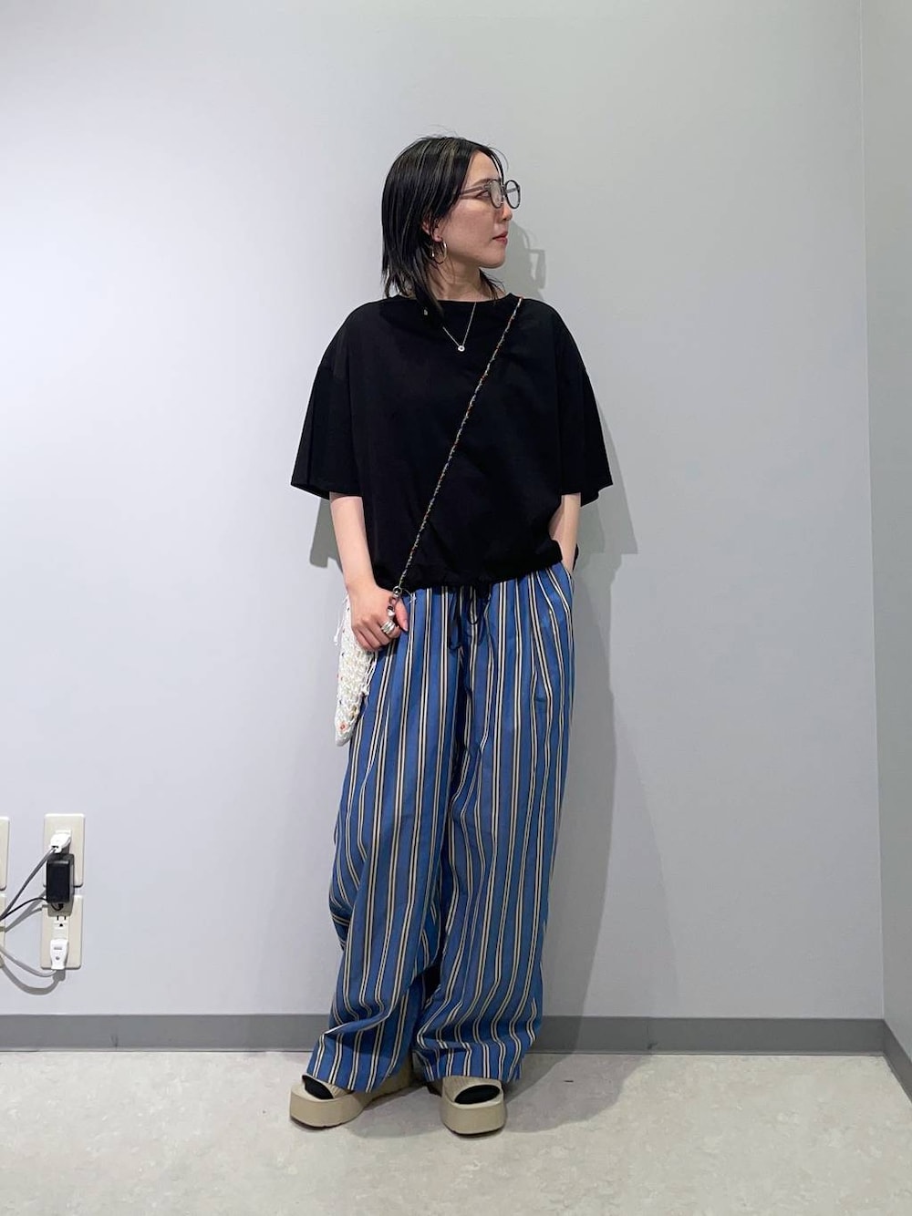 ブルー系のその他パンツ、ホワイト系のサンダル、その他のショルダーバッグを着用したレディースの春コーディネートの1枚目の写真