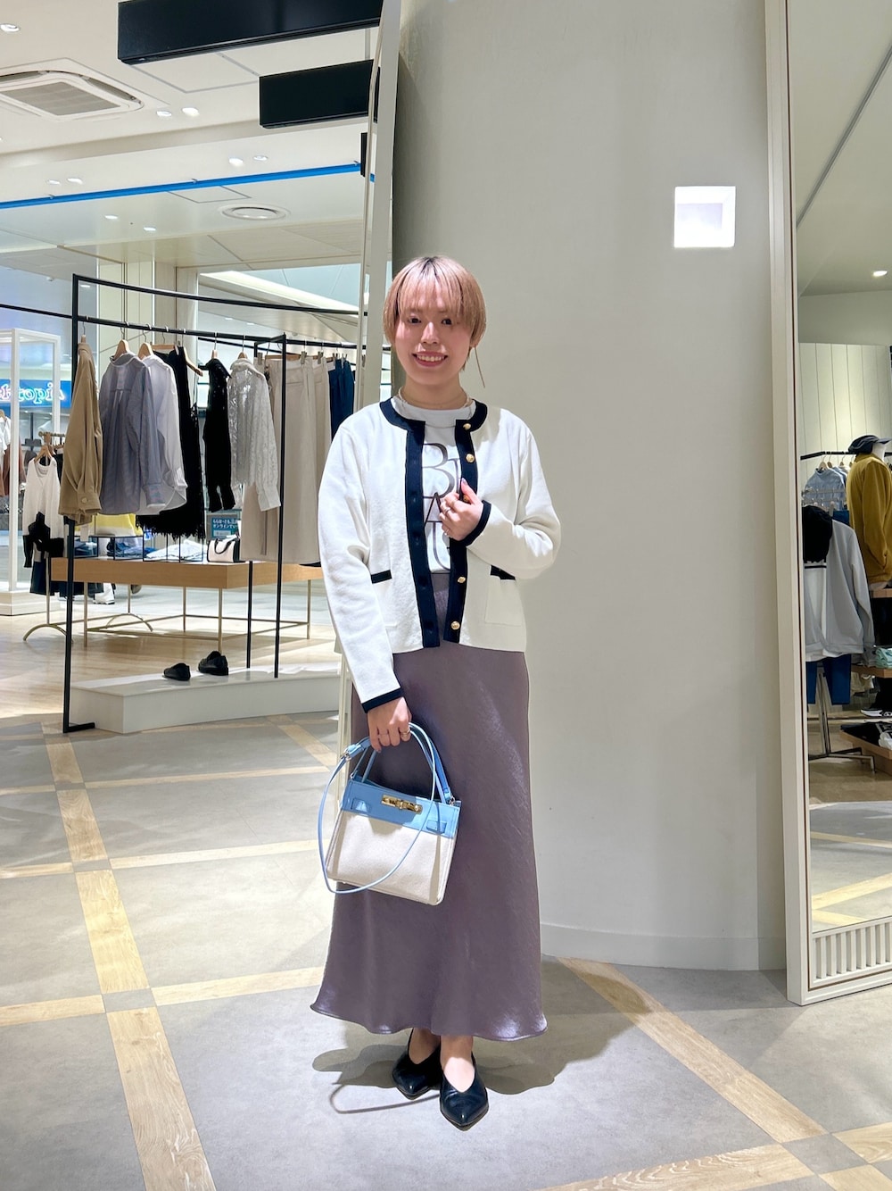 ブルー系のTシャツ/カットソー、グリーン系のスカート、ホワイト系のカーディガン/ボレロを着用したレディースの春コーディネートの1枚目の写真