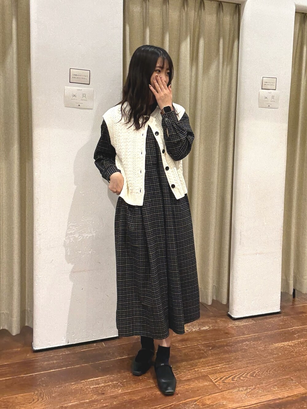 ブラック系のワンピース、ホワイト系のベストを着用したレディースの秋コーディネートの1枚目の写真