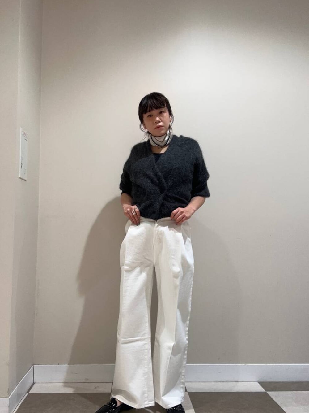 ホワイト系のデニムパンツ、ブラック系のローファー、ブラック系のタンクトップを着用したレディースの冬コーディネートの1枚目の写真