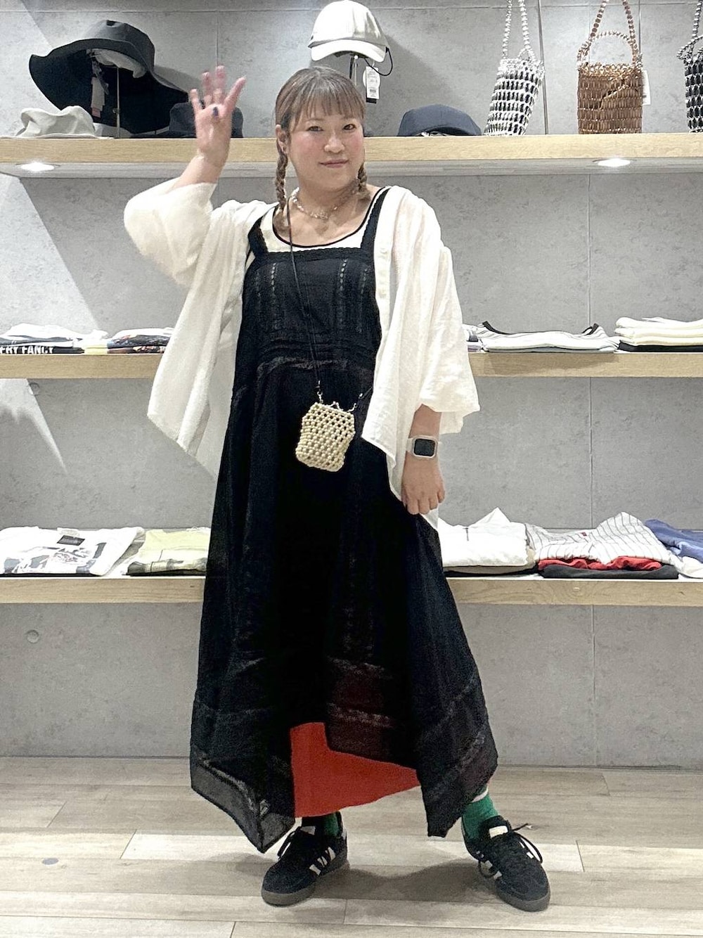 オレンジ系のスカート、ブラック系のワンピース、ベージュ系のシャツ/ブラウスを着用したレディースの夏コーディネートの1枚目の写真