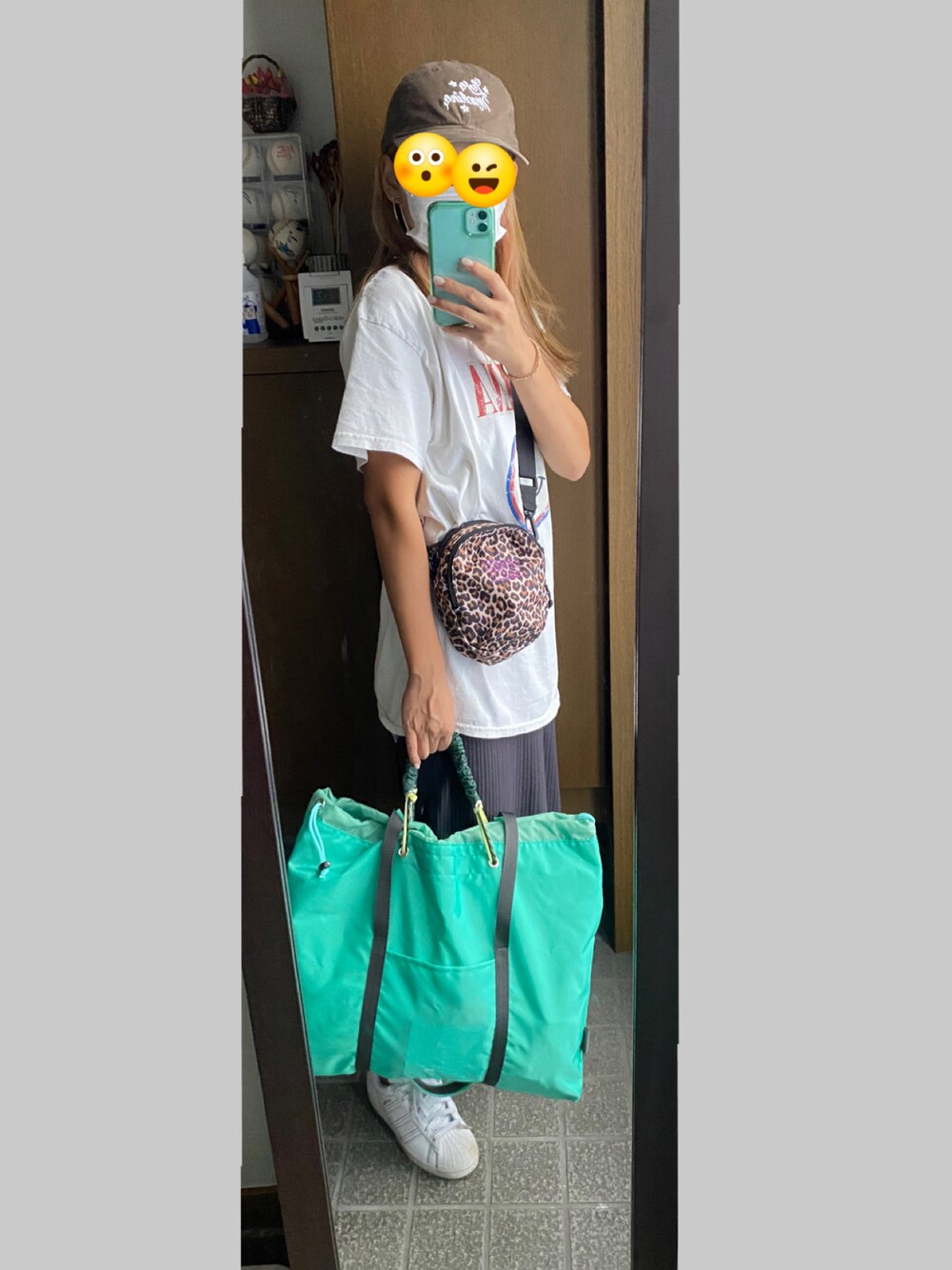 ホワイト系のスニーカー、グリーン系のスカート、グリーン系のトートバッグを着用したレディースの秋コーディネートの1枚目の写真