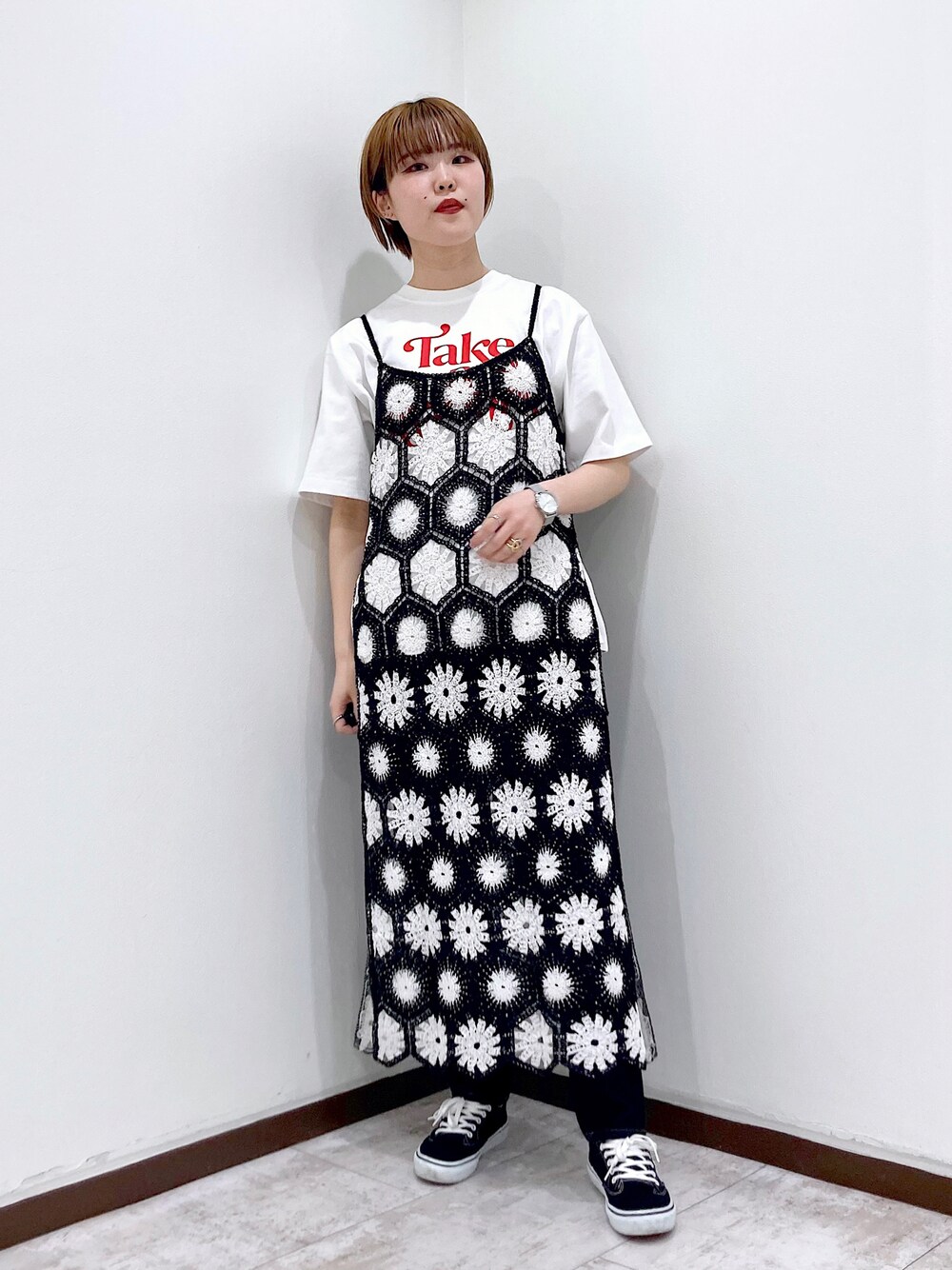 ブラック系のワンピース、ホワイト系のTシャツ/カットソー、ブルー系のデニムパンツを着用したレディースの春コーディネートの1枚目の写真