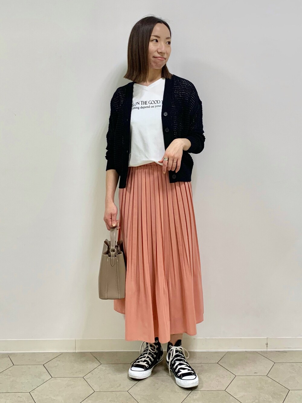 ホワイト系のTシャツ/カットソー、ブラック系のカーディガン/ボレロ、ピンク系のスカートを着用したレディースの春コーディネートの1枚目の写真