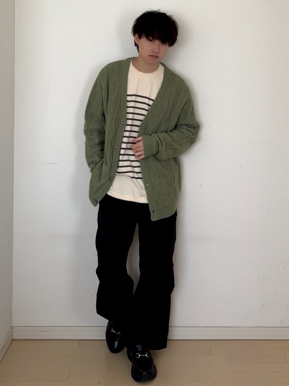 ブラック系のカーゴパンツ、ブラック系のスニーカー、グリーン系のTシャツ/カットソーを着用したメンズの春コーディネートの1枚目の写真