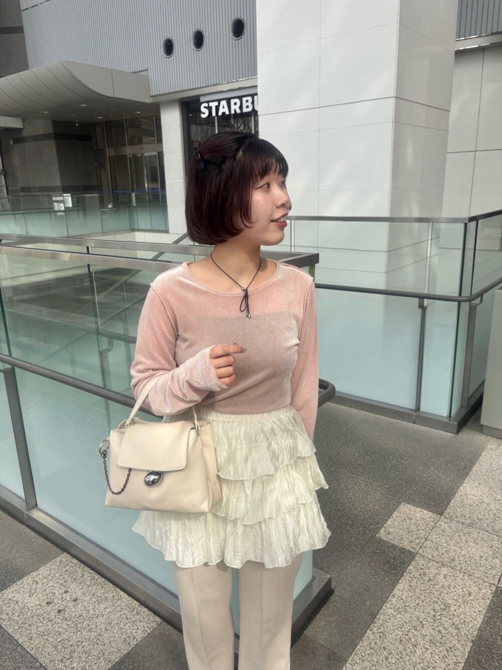 ピンク系のTシャツ/カットソー、ホワイト系のスカート、ホワイト系のショルダーバッグを着用したレディースの春コーディネートの1枚目の写真