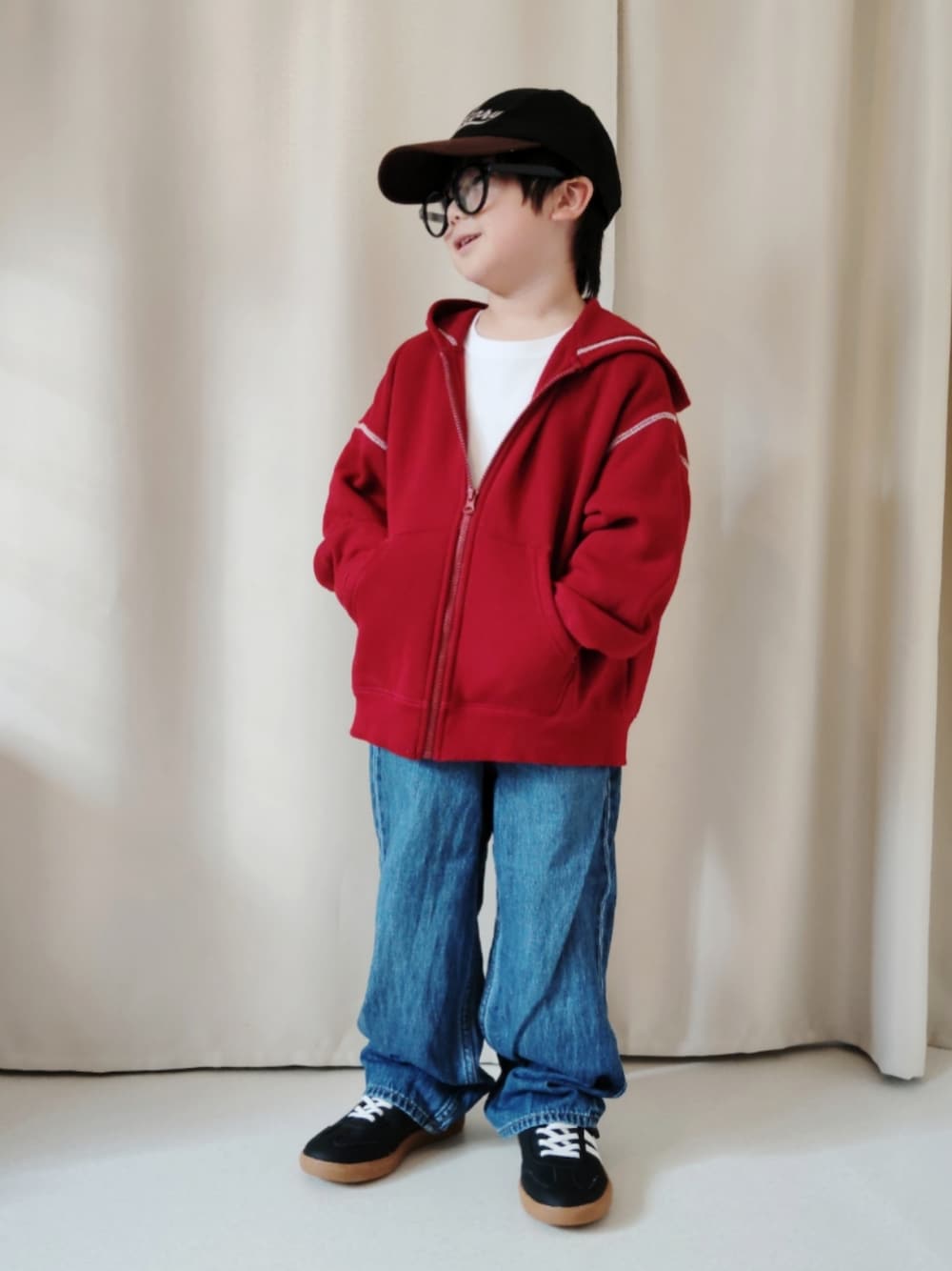 レッド系のパーカー、ホワイト系のTシャツ/カットソー、ブルー系のデニムパンツを着用したキッズの冬コーディネートの1枚目の写真