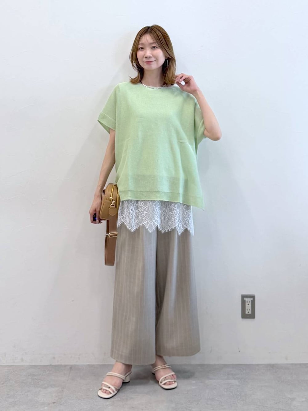 ホワイト系のサンダル、ベージュ系のその他パンツ、ホワイト系のTシャツ/カットソーを着用したレディースの春コーディネートの1枚目の写真