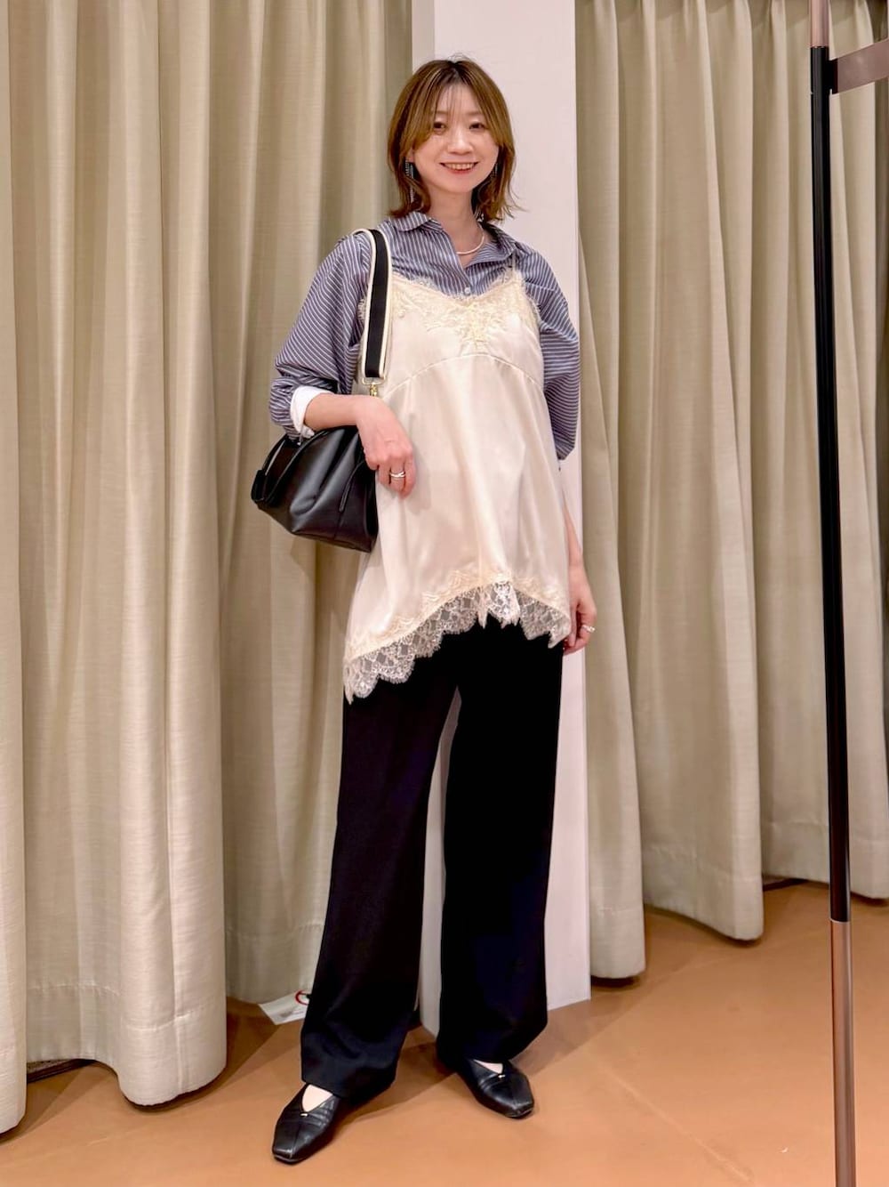 ブラック系のその他パンツ、ブラック系のパンプス、ホワイト系のキャミソールを着用したレディースの春コーディネートの1枚目の写真