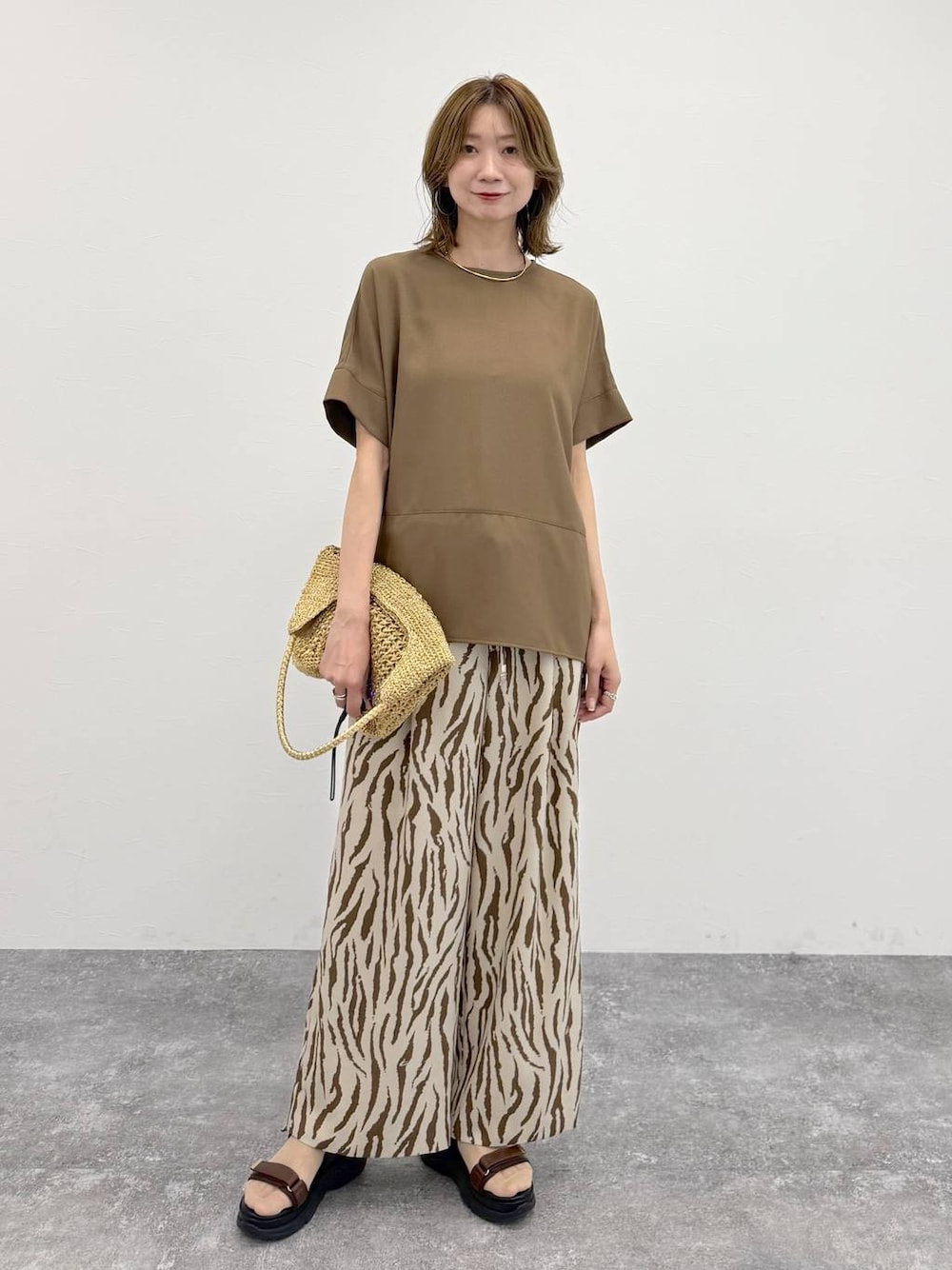 ゴールド系のトートバッグ、その他のその他パンツ、ブラウン系のTシャツ/カットソーを着用したレディースの春コーディネートの1枚目の写真