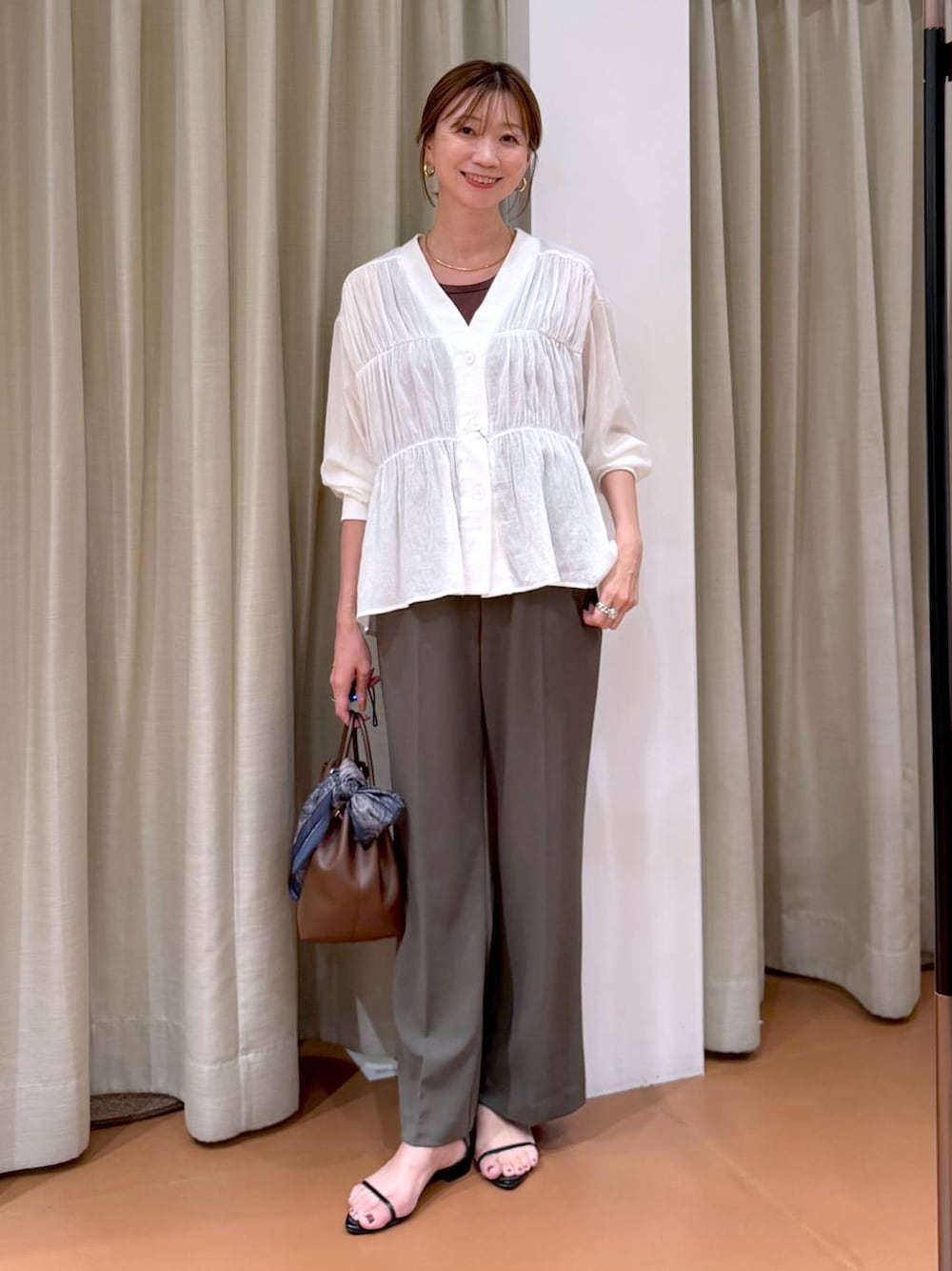 グリーン系のその他パンツ、ホワイト系のシャツ/ブラウス、ブラウン系のタンクトップを着用したレディースの秋コーディネートの1枚目の写真