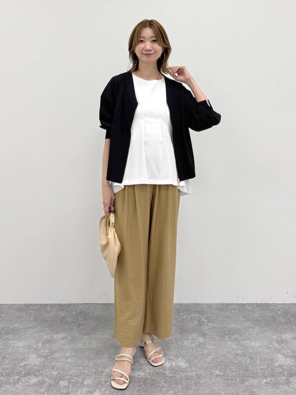 ベージュ系のその他パンツ、ブラック系のカーディガン/ボレロ、ホワイト系のTシャツ/カットソーを着用したレディースの春コーディネートの1枚目の写真