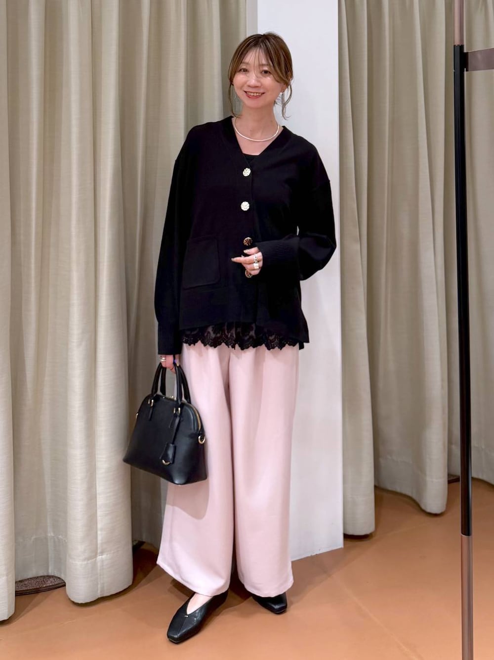 ブラック系のハンドバッグ、ブラック系のパンプス、ブラック系のタンクトップを着用したレディースの冬コーディネートの1枚目の写真