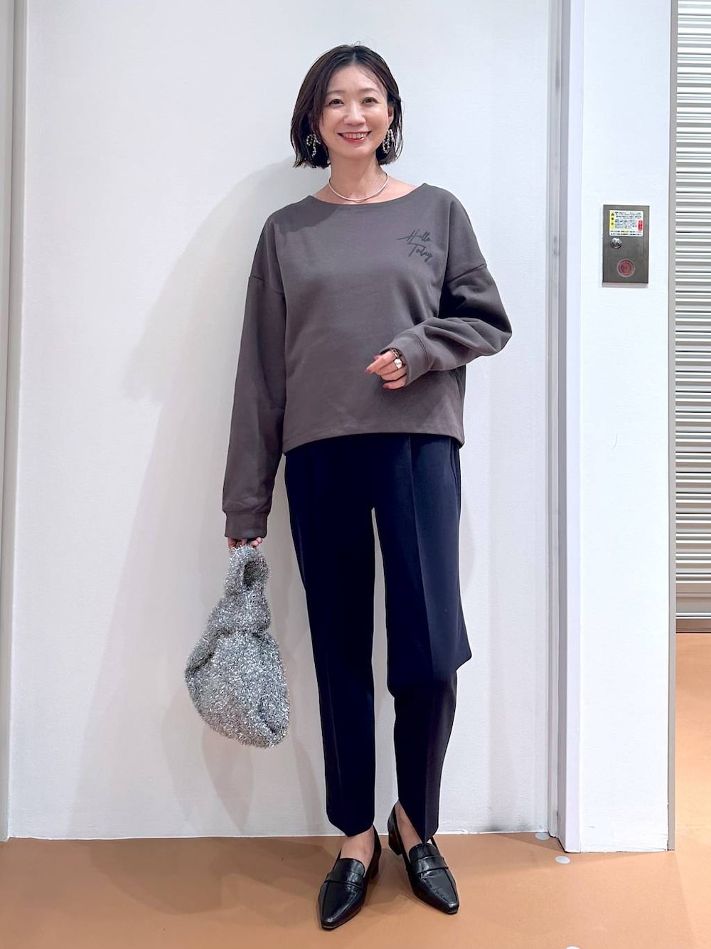 ブルー系のその他パンツ、ブラック系のローファー、シルバー系のハンドバッグを着用したレディースの秋コーディネートの1枚目の写真
