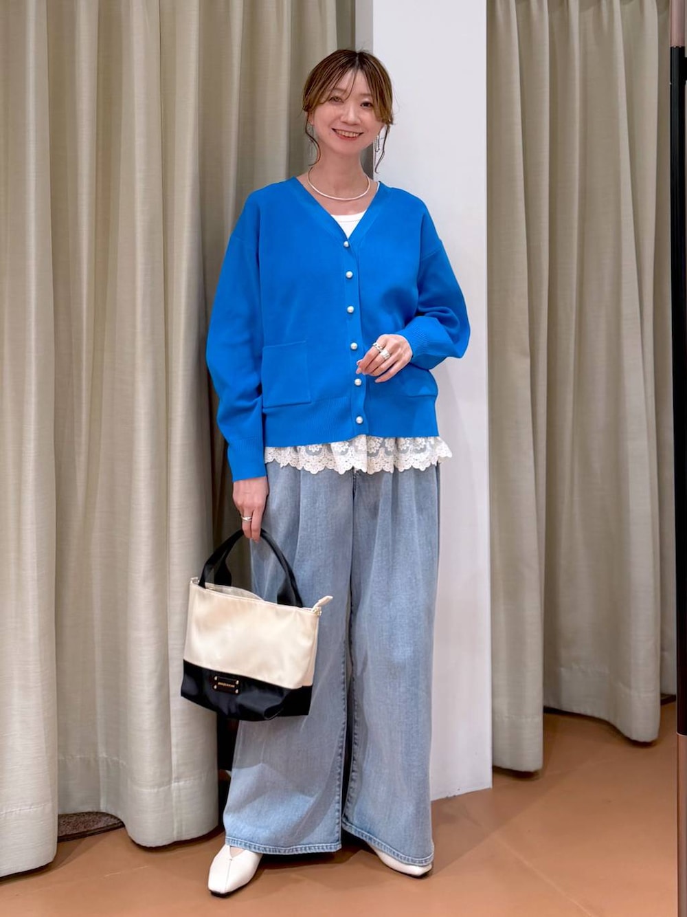 ホワイト系のパンプス、ホワイト系のタンクトップ、ブルー系のデニムパンツを着用したレディースの春コーディネートの1枚目の写真