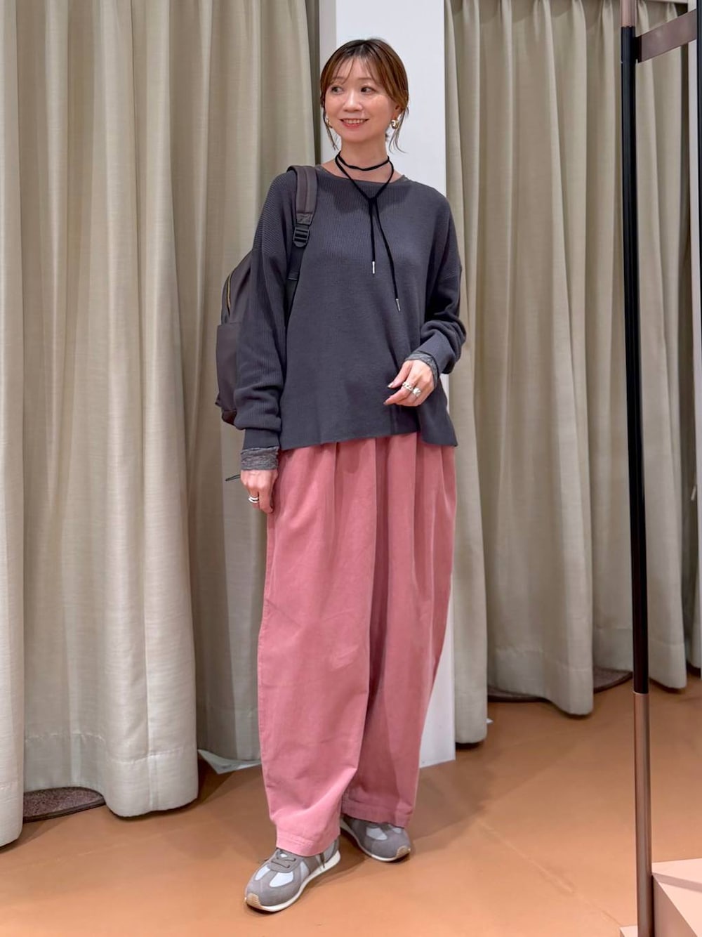ピンク系のその他パンツ、グレー系のニット/セーター、グレー系のスニーカーを着用したレディースの秋コーディネートの1枚目の写真