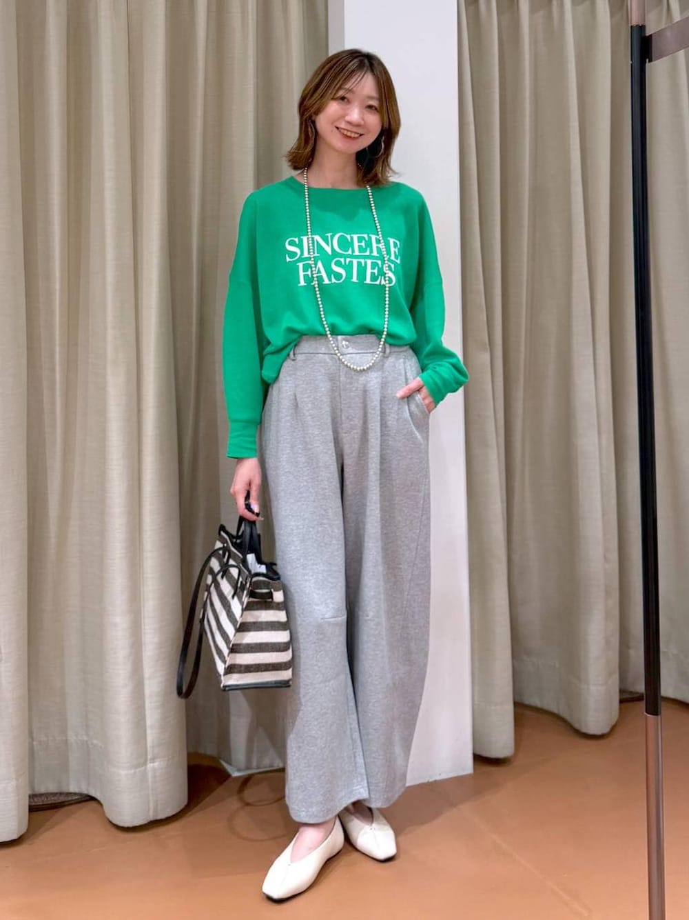 ホワイト系のパンプス、グレー系のスウェットパンツ、ブラック系のトートバッグを着用したレディースの春コーディネートの1枚目の写真