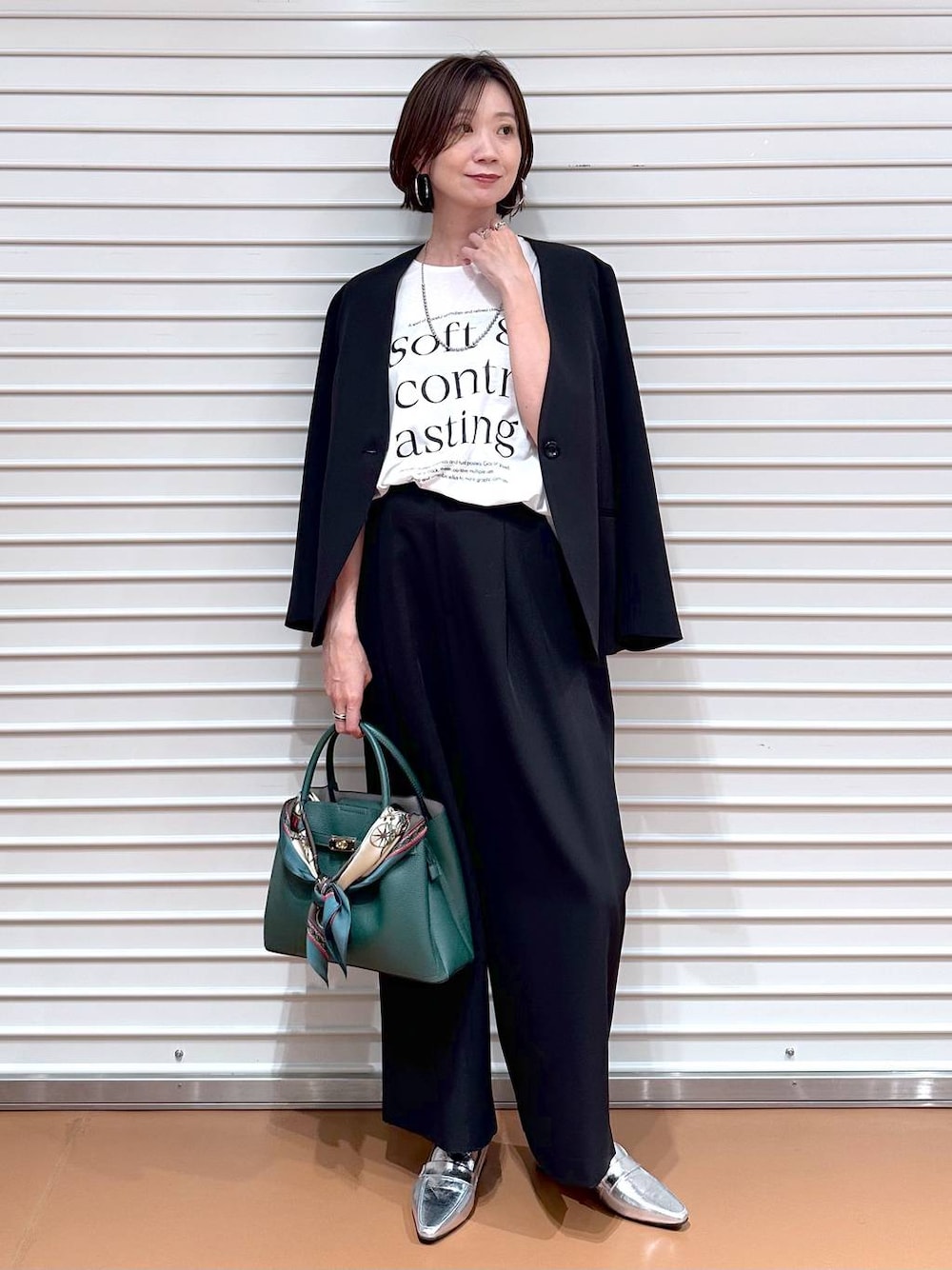 ブラック系のその他アウター、ブラック系のその他パンツ、ホワイト系のTシャツ/カットソーを着用したレディースの秋コーディネートの1枚目の写真