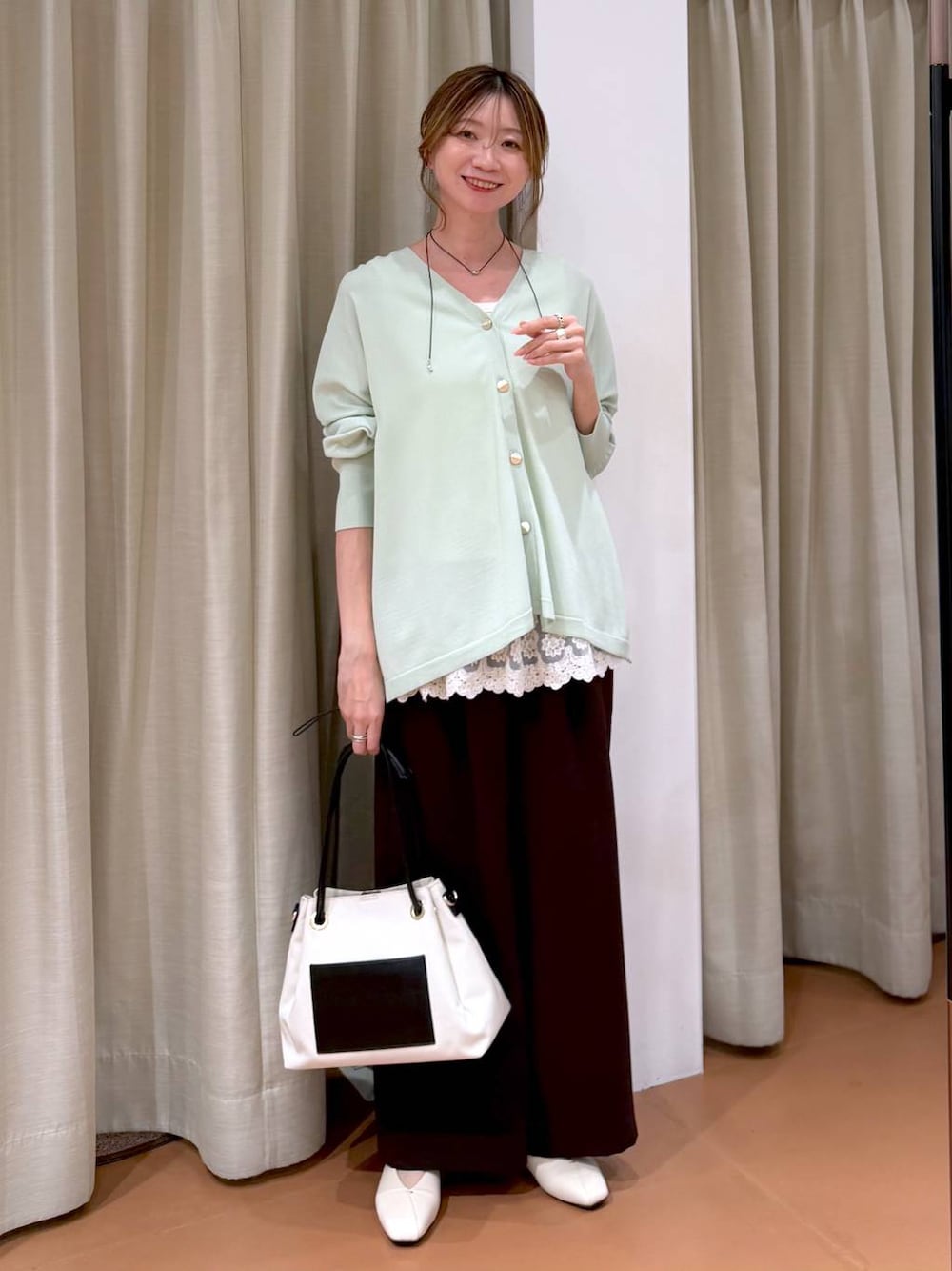 ホワイト系のパンプス、ホワイト系のタンクトップ、ホワイト系のトートバッグを着用したレディースの春コーディネートの1枚目の写真