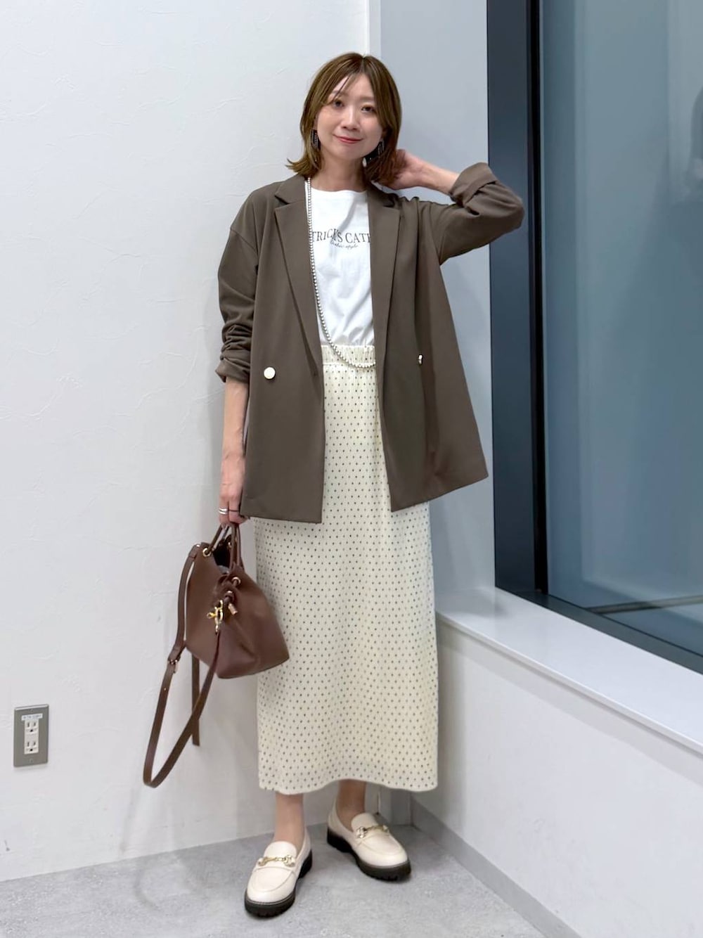 ホワイト系のスカート、ホワイト系のローファー、ホワイト系のTシャツ/カットソーを着用したレディースの冬コーディネートの1枚目の写真