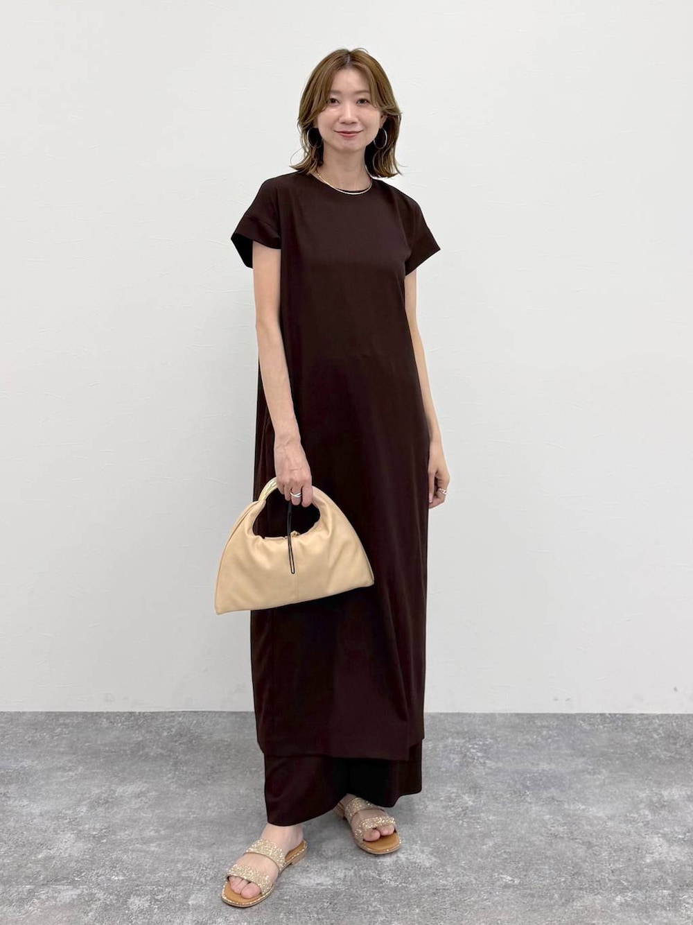 ブラウン系のその他パンツ、ブラウン系のワンピース、ゴールド系のネックレスを着用したレディースの春コーディネートの1枚目の写真