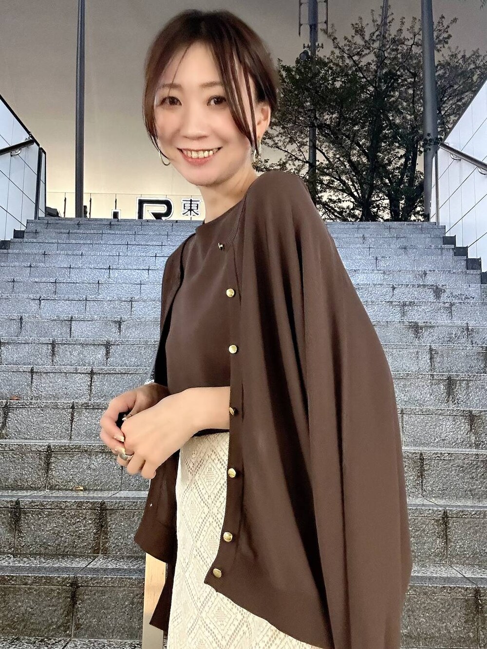 ブラウン系のカーディガン/ボレロ、ブラウン系のニット/セーター、ホワイト系のパンプスを着用したレディースの春コーディネートの1枚目の写真