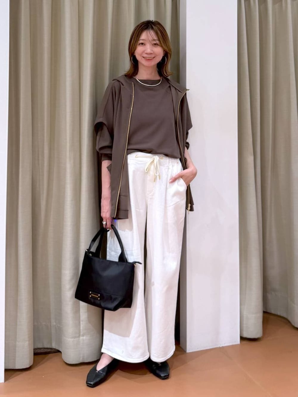 ブラック系のパンプス、ホワイト系のデニムパンツ、ブラウン系のTシャツ/カットソーを着用したレディースの春コーディネートの1枚目の写真