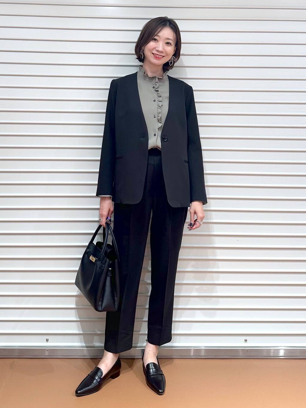 ブラック系のその他アウター、ブラック系のその他パンツ、ブラック系のハンドバッグを着用したレディースの秋コーディネートの1枚目の写真