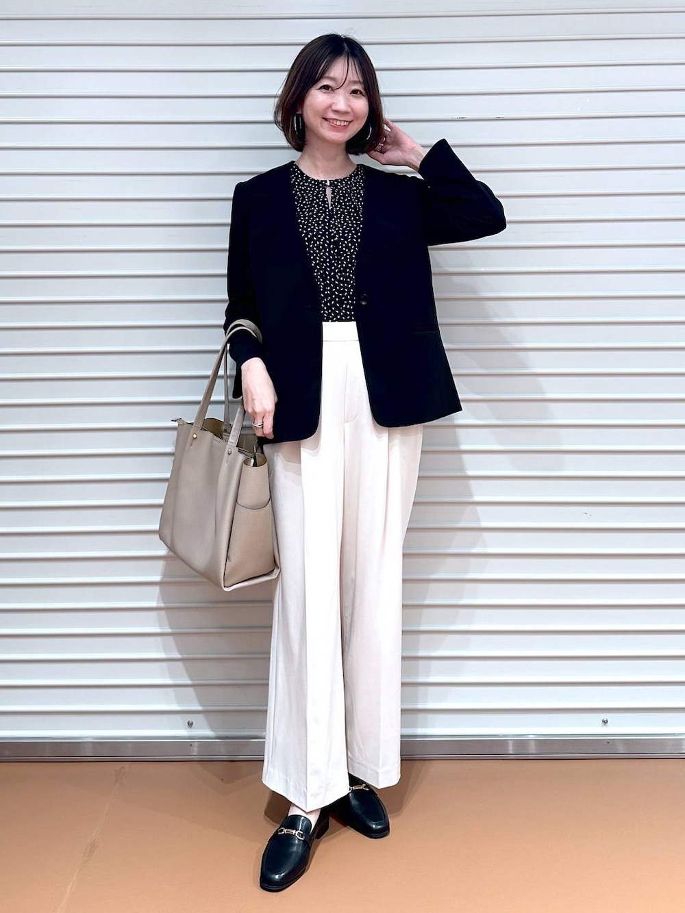 ブラック系のシャツ/ブラウス、ホワイト系のその他パンツ、ベージュ系のトートバッグを着用したレディースの春コーディネートの1枚目の写真