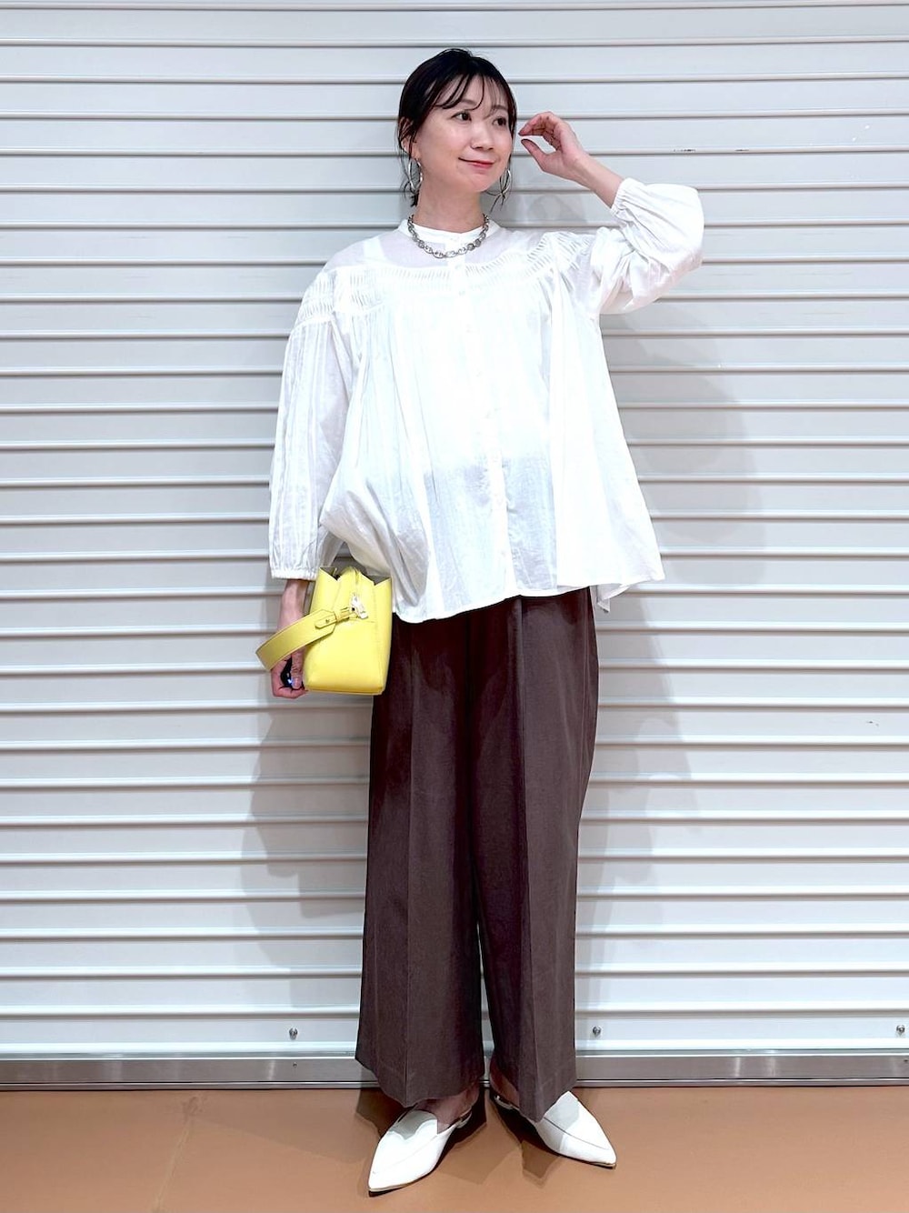 ブラウン系のその他パンツ、ブラウン系のその他パンツ、イエロー系のハンドバッグを着用したレディースの夏コーディネートの1枚目の写真