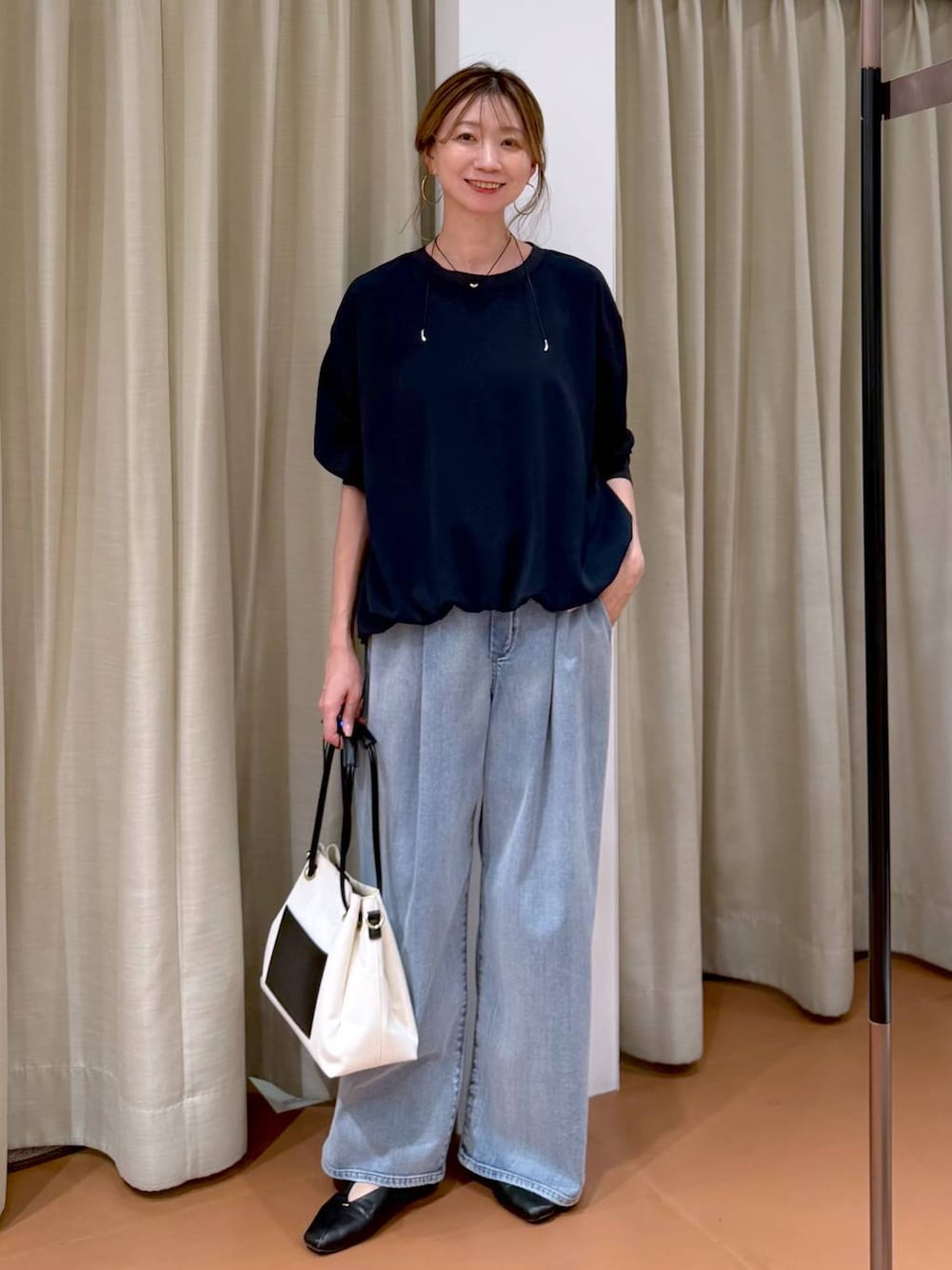 ホワイト系のパンプス、ブルー系のデニムパンツ、ホワイト系のトートバッグを着用したレディースの春コーディネートの1枚目の写真