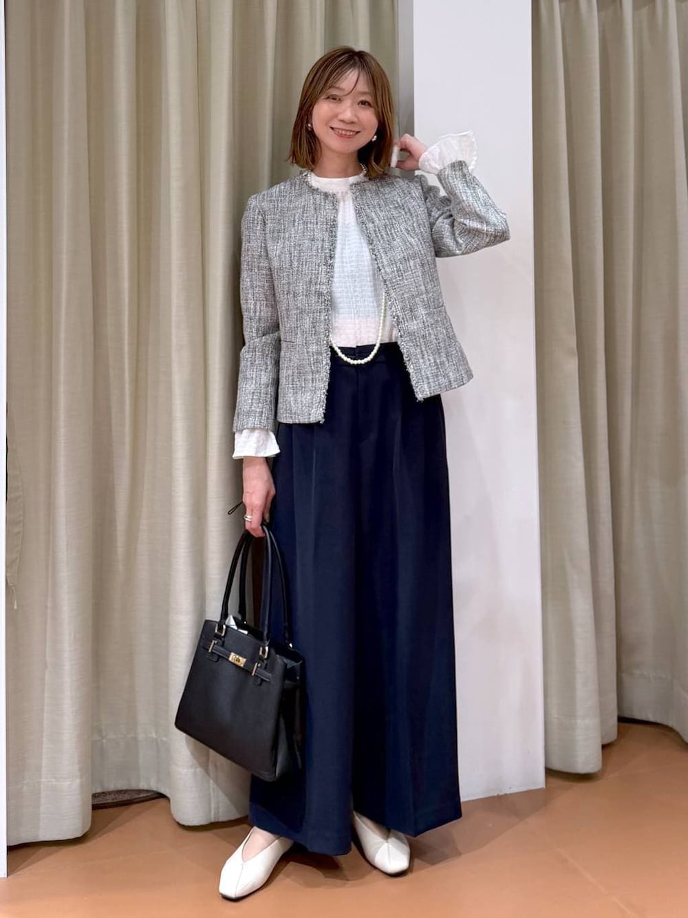 ホワイト系のパンプス、ホワイト系のシャツ/ブラウス、ブラック系のノーカラージャケットを着用したレディースの冬コーディネートの1枚目の写真