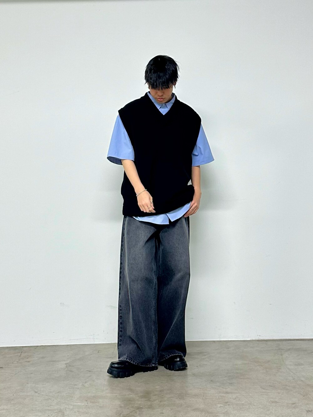 ブラック系のベスト、ブルー系のシャツ/ブラウス、ブラック系のデニムパンツを着用したメンズの春コーディネートの1枚目の写真