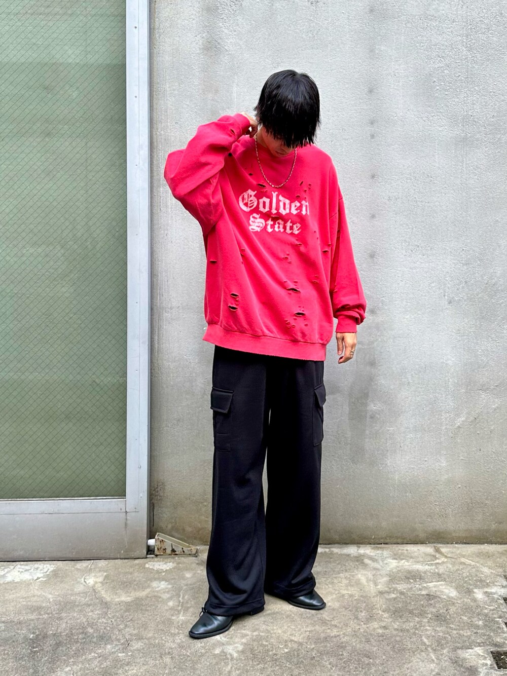 レッド系のスウェット、ブラック系のカーゴパンツを着用したメンズの秋コーディネートの1枚目の写真