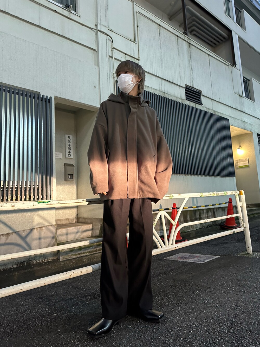 ベージュ系のカバーオール、ブラック系のその他パンツ、ブラック系のブーツを着用したメンズの冬コーディネートの1枚目の写真