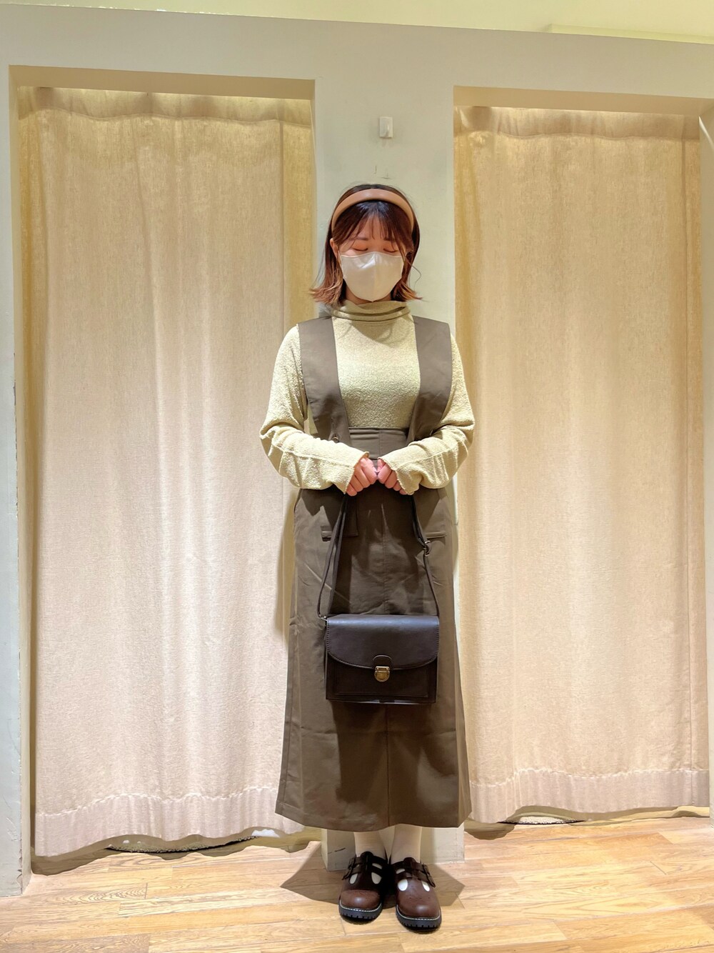 ベージュ系のトップス、ブラウン系のスカート、ブラウン系のショルダーバッグを着用したレディースの秋コーディネートの1枚目の写真